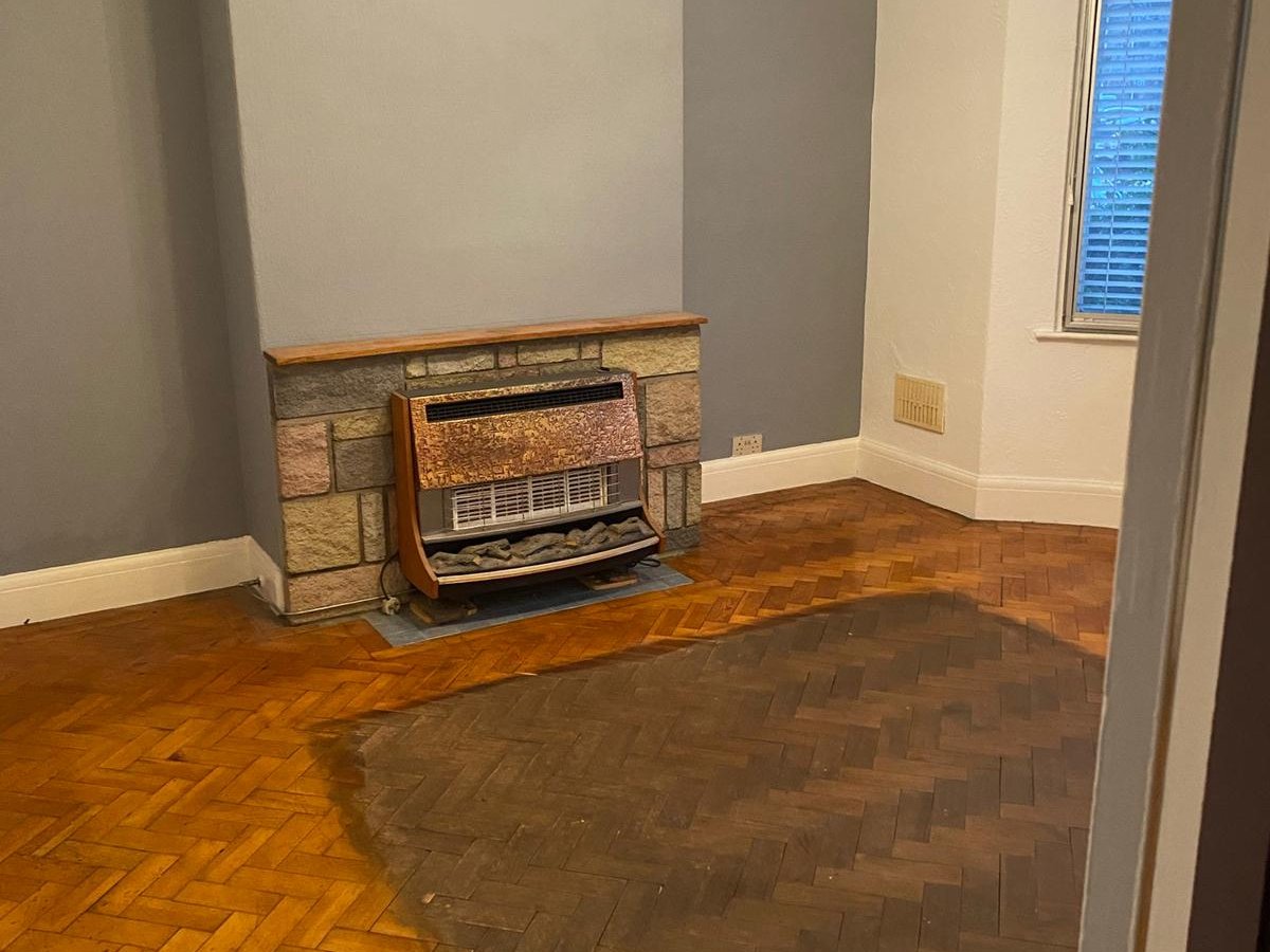 Tired stained parquet floor before restoration